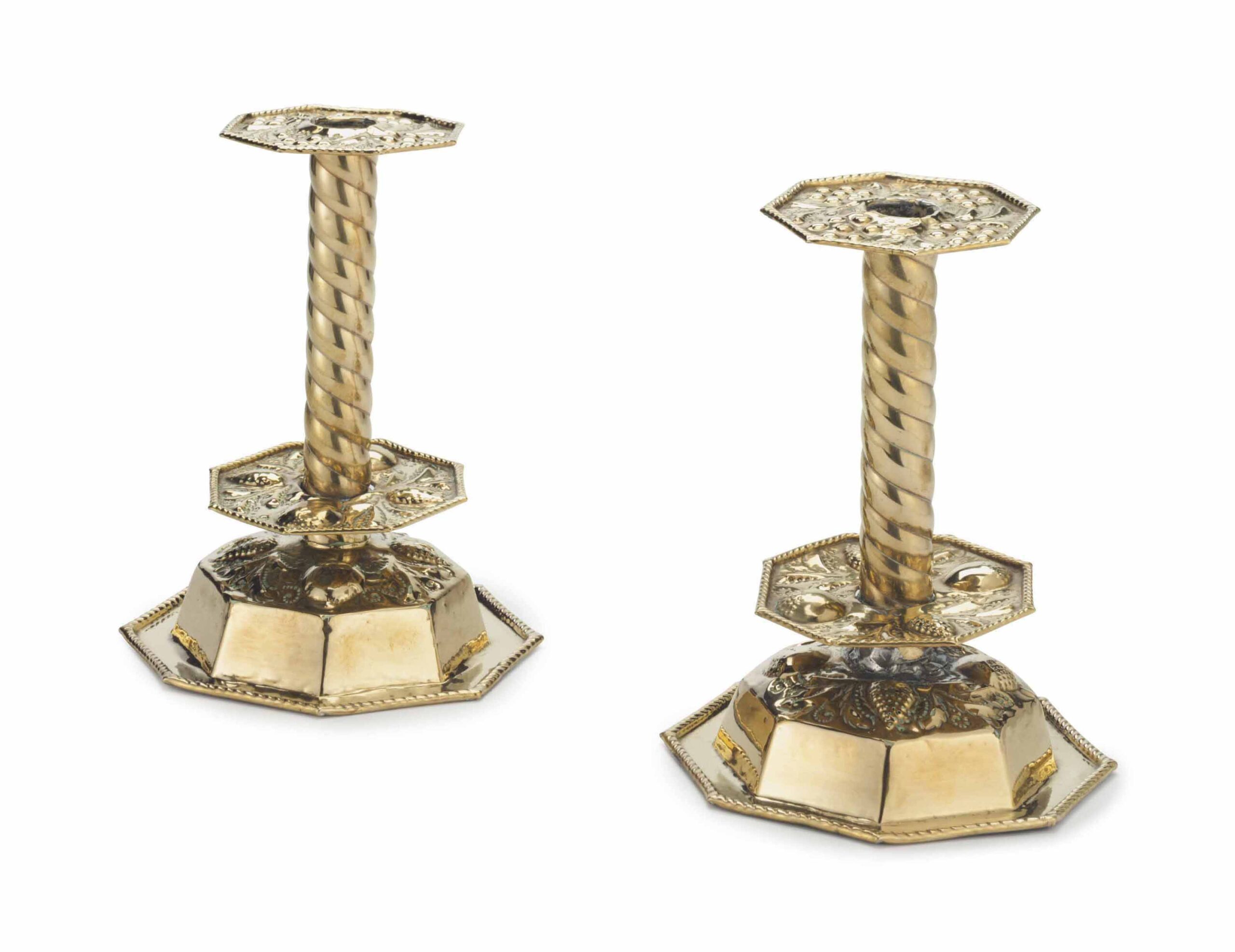 A PAIR OF NORTH EUROPEAN REPOUSSE BRASS CANDLESTICKS